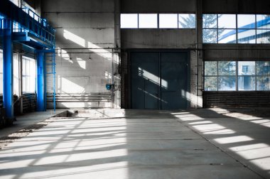 Üretim Fabrikası. Boş hangar binası. Mavi tonlu arka plan. Büyük pencereler ve metal yapılar ile üretim Oda