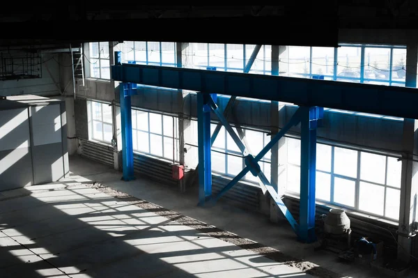 Fertigungsfabrik. Leere Hangargebäude. blaugetönter Hintergrund. der Produktionsraum mit großen Fenstern und Metallkonstruktionen — Stockfoto