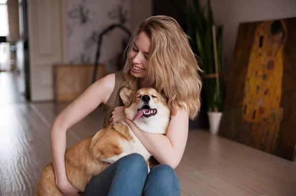 Gülümseyen kız mutlu sevimli köpek onu Galce Corgi Pembroke köpekle oynayan. Köpek sahipleri elinde yalan