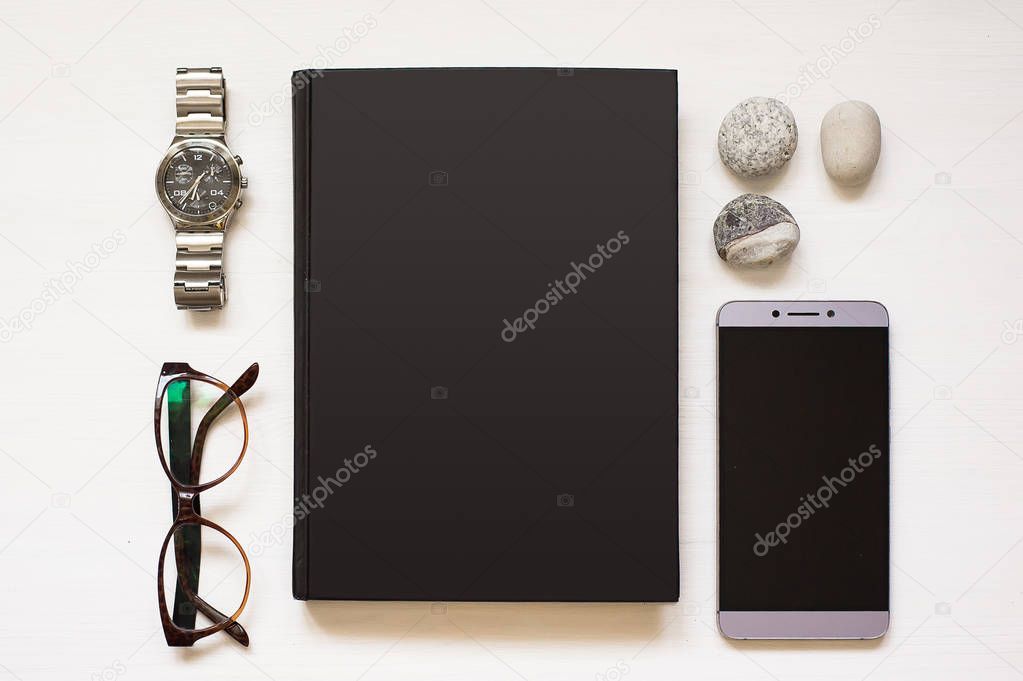 Blank black notebook isolated on white textured wood background with business man's things. Flat Lay book. Top View. Copy space 