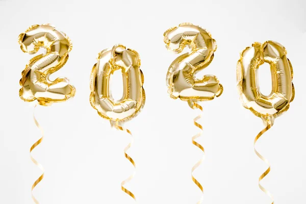 Feliz Año Nuevo 2020 celebración. Números globos de lámina dorada 2020 colgando en el aire sobre fondo blanco —  Fotos de Stock
