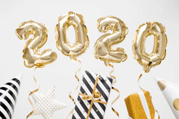 Feliz Año Nuevo 2020 celebración. Globos dorados numeral 2020 sobre fondo blanco con regalos —  Fotos de Stock