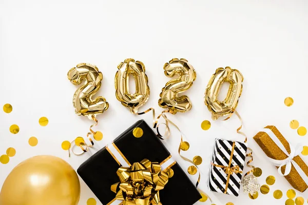 Feliz Año Nuevo 2020 celebración. Globos dorados numeral 2020 sobre fondo blanco con regalos —  Fotos de Stock