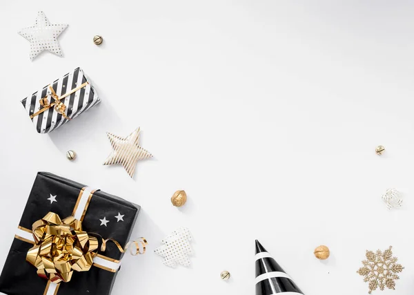 时尚的圣诞装饰。 白色背景的礼物、帽子、黑色和金色装饰 — 图库照片