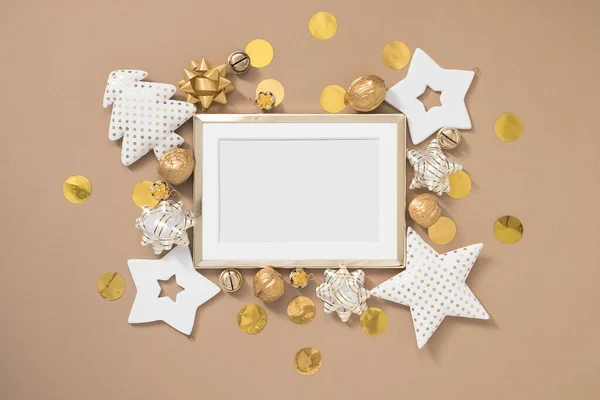 Marco dorado navideño con decoraciones blancas y doradas sobre fondo beige pastel. Plano, vista superior, espacio para copiar — Foto de Stock