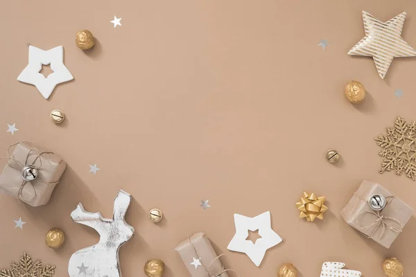 Рождественская композиция Рамка с подарками, ремеслом и золотыми украшениями на пастельно-бежевом фоне . — стоковое фото
