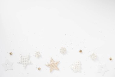 Noel sınırı. Altın yıldızlar, beyaz arka planda çanlar ve fiyonklar. Düz konum, üst görünüm, kopyalama alanı