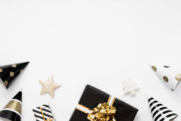 Різдвяні плоскогубці. Різдвяні подарунки, чорно-золоті прикраси на білому тлі. Плоский простір, вид зверху, простір для копіювання — стокове фото