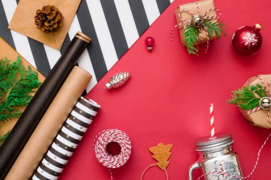 Hediye kutuları, ipler, kağıtlar kırmızı üzerine süslemeler olan Noel arkaplanı. Tatil hazırlığı