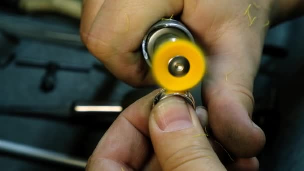 Handen van de juwelier polijsten ring op de polijstmachine. Goldsmith werkt aan zijn werkbank — Stockvideo