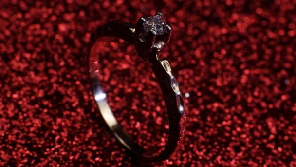 Krásný lesklý zlatý zásnubní prsten s velkým drahokamem diamant na třpytivém červeném pozadí. Dárek k Valentýnu. Návrh na sňatek na 14. února — Stock video