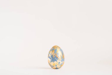 Beyaz arka planda izole edilmiş altın potansiyeli olan Paskalya yumurtası. Asgari paskalya konsepti. Metin Üst görünümü ve düz görünümü için kopyalama alanı olan Mutlu Paskalyalar kartı. 