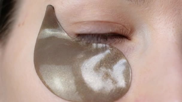 Belle femme regardant la caméra avec des patchs collagène hydrogel. Comment appliquer des patchs cosmétiques sous les yeux. Soins de la peau . — Video