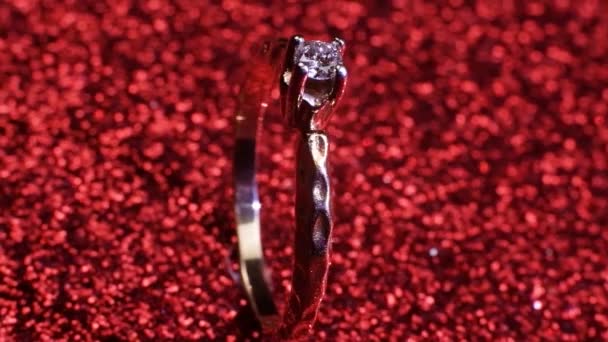 Belle bague de fiançailles dorée brillante avec gros diamant gemme sur fond rouge paillettes. st Saint Valentin cadeau . — Video