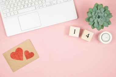Ev ofisinin masası düzdü. Dizüstü bilgisayarlı, kozmetik ürünlü, parfümlü, pembe arka planda aksesuarlı kadınlar. Aşk mektubu, sevgililer günü kırmızı kalbi.