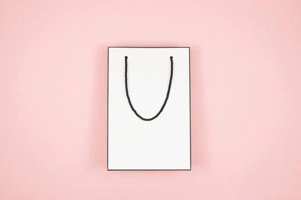 Banner, selebaran atau poster tiruan untuk penjualan Hari Ibu, tas belanja putih dengan latar belakang merah muda. Sebuah kantong kertas untuk berbelanja dengan hati merah. Hari Valentine, Happy Womens Day . — Stok Foto