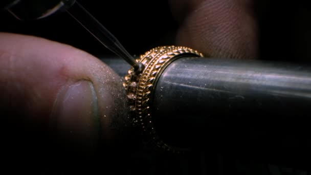 Goldsmith met behulp van een boorgereedschap om een gat te maken in de gouden ring. Juwelier boort een gat voor het plaatsen van een edelsteen. — Stockvideo