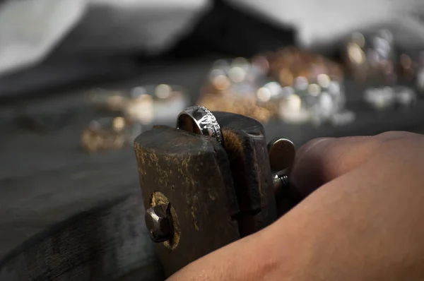 Close-up of hand of a goldsmith setting the diamond on the ring. Craft jewelery making with professional tools. — Stock Photo, Image