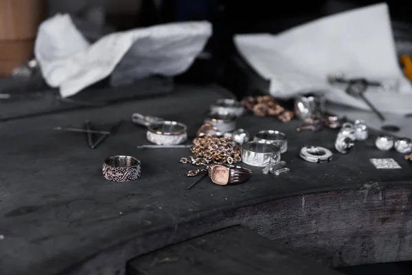Close-up de anéis inacabados na mesa de ourives. Jóias no processo de fabricação. Fabricação de jóias artesanais com ferramentas profissionais . — Fotografia de Stock