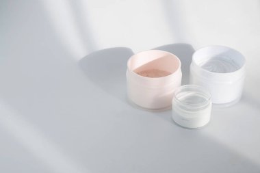 Kavanozda mavi kil yüzlü maskeyle yatıyordu. Yüz kozmetik ürünleri ile güzellik geçmişi. Spa konsepti. Güzellik blogcusu, salon tedavileri konsepti. Minimalizm.