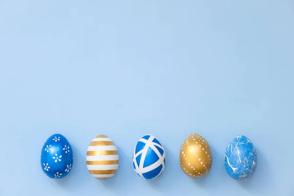 Marco de huevos dorados de Pascua decorados en nido sobre fondo azul para banner web. Mínimo concepto de Pascua. Tarjeta de Pascua feliz con espacio de copia para el texto. Vista superior, plano . — Foto de Stock