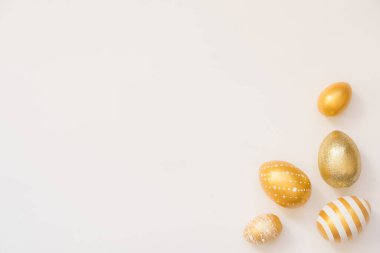 Paskalya altın madalyalı yumurta çerçevesi beyaz arka planda. Asgari paskalya konsepti. Mesaj için fotokopi alanı olan mutlu Paskalyalar. Üst görünüm, düz görünüm