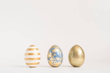 Mavi arka planda üç Paskalya yumurtası. Asgari paskalya konsepti. Mesaj için fotokopi alanı olan mutlu Paskalyalar. Üst görünüm, düz görünüm