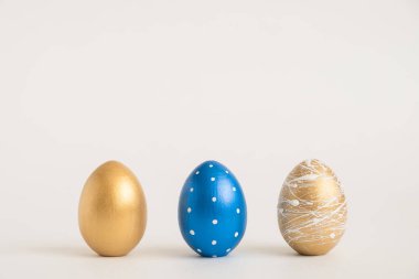 Mavi arka planda üç Paskalya yumurtası. Asgari paskalya konsepti. Mesaj için fotokopi alanı olan mutlu Paskalyalar. Üst görünüm, düz görünüm