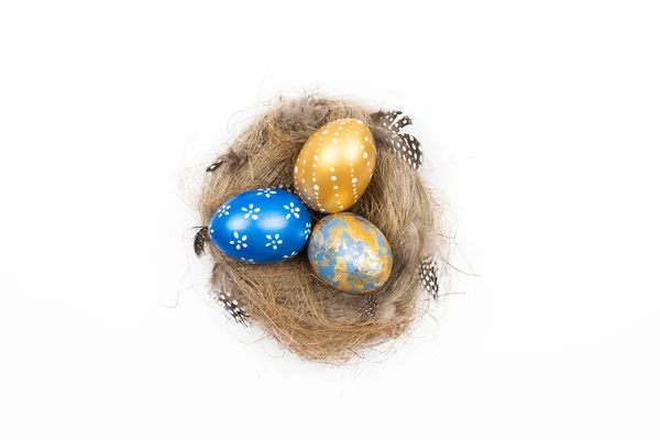Frame of Easter golden decorated eggs in nest isolated on white background for web banner. Minimal easter concept. Happy Easter card with copy space for text. Top view, flatlay. Royalty Free Stock Photos
