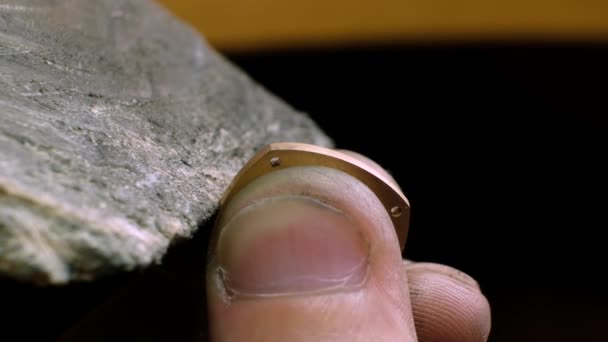 Ο Γκόλντσμιθ γυαλίζει ένα χρυσό δαχτυλίδι. Κοσμηματοπώλης στην εργασία σε εργαστήριο κοσμηματοποιίας — Αρχείο Βίντεο