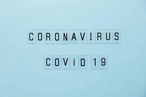 Fogantatás Coronavirus. A COVID-19 terjedésének megelőzése vagy megállítása világszerte. Levelek kék háttérrel. — Stock Fotó