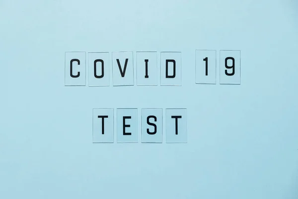 Virustest von Coronavirus. Die weltweite Verbreitung der COVID-19 verhindern oder stoppen. Buchstabentest auf blauem Hintergrund. — Stockfoto