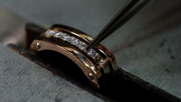 Ambachtelijke sieraden maken. Goldsmith zet de diamant op de ring. Macro-injectie. — Stockvideo