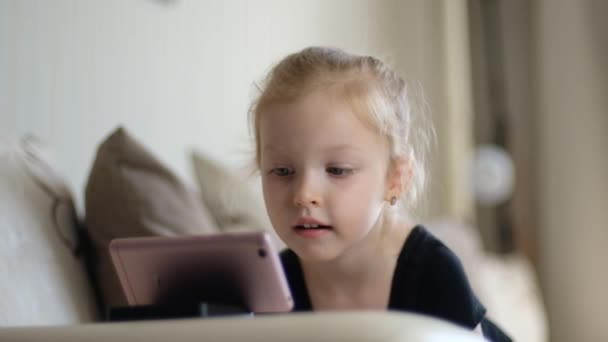 Uzaktan öğrenme, çocuklar için online eğitim. Küçük kız akıllı telefonun önünde evde ders çalışıyor. Çocuk online çizgi film izliyor, çocuk bilgisayar bağımlısı, ebeveyn kontrolü. Evde karantina — Stok video