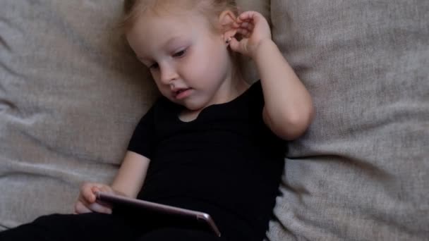 Távolságtanulás, online oktatás gyerekeknek. A kislány otthon tanul az okostelefon előtt. Gyerek online rajzfilmeket néz, gyerekek számítógép-függőség, szülői felügyelet. Karantén otthon — Stock videók