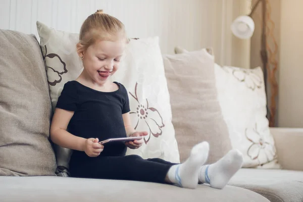 Felice divertente ragazza giocare su smartphone. Bambino che guarda cartoni animati online, bambini dipendenza dal computer, controllo parentale. Apprendimento a distanza, educazione online per bambini. Quarantena a casa — Foto Stock