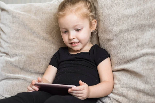 Apprendimento a distanza, educazione online per bambini. Bambina che studia a casa davanti allo smartphone. Bambino che guarda cartoni animati online, bambini dipendenza dal computer, controllo parentale. Quarantena a casa — Foto Stock