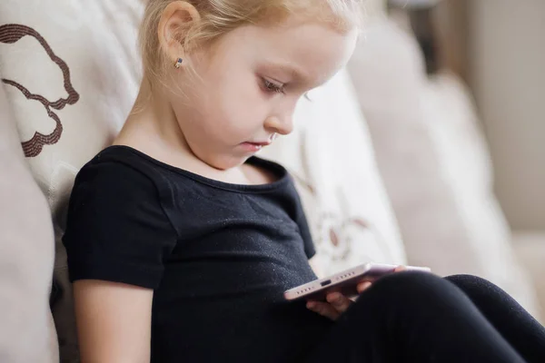 Apprendimento a distanza, educazione online per bambini. Bambina che studia a casa davanti allo smartphone. Bambino che guarda cartoni animati online, bambini dipendenza dal computer, controllo parentale. Quarantena a casa — Foto Stock