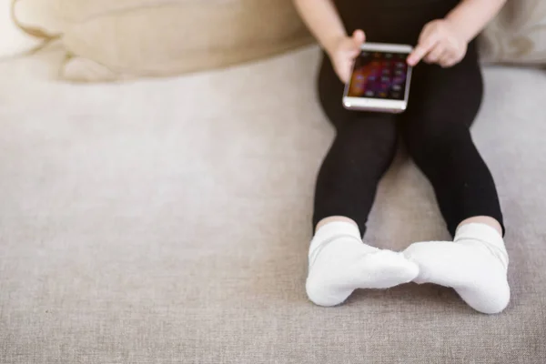 Apprendimento a distanza, educazione online per bambini. Bambina che studia a casa davanti allo smartphone. Bambino che guarda cartoni animati online, bambini dipendenza dal computer, controllo parentale. Quarantena a casa — Foto Stock