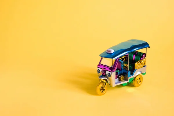 Modell Toy Tuk Tuk isoliert auf gelbem Hintergrund. Thailändisches traditionelles Taxi in Bangkok Thailand. Souvenir — Stockfoto