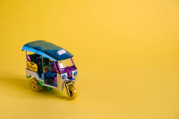 Modell Toy Tuk Tuk isoliert auf gelbem Hintergrund. Thailändisches traditionelles Taxi in Bangkok Thailand. Souvenir — Stockfoto