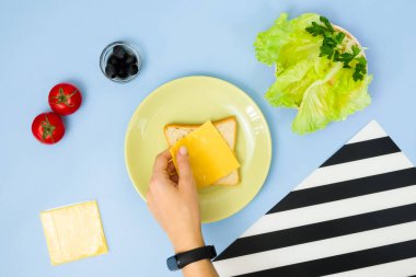Çocuklar için eğlenceli yemek sanatı. Mavi arka planda uğur böceği sandviçi. Evde çocuklara yaratıcı kahvaltı hazırlamayı. Adım adım talimat, yukarıdan görüş. Adım 2.
