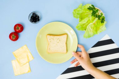 Çocuklar için eğlenceli yemek sanatı. Mavi arka planda uğur böceği sandviçi. Evde çocuklara yaratıcı kahvaltı hazırlamayı. Adım adım talimat, yukarıdan görüş. Adım 2.