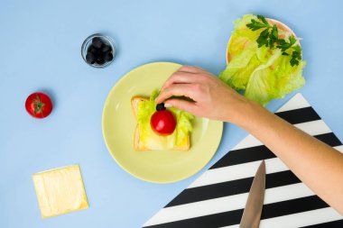 Çocuklar için eğlenceli yemek sanatı. Mavi arka planda uğur böceği sandviçi. Evde çocuklara yaratıcı kahvaltı hazırlamayı. Adım adım talimat, yukarıdan görüş. Beşinci adım. .