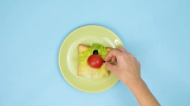Çocuklar için eğlenceli yemek sanatı. Mavi arka planda uğurböceği sandviçi hazırlama işlemi. Evde çocuklara yaratıcı kahvaltı hazırlamayı. Adım adım talimat, yukarıdan görüş. Kolaj.