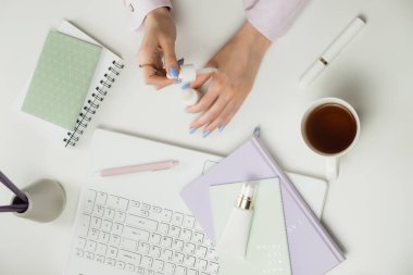 Kadın güzellik blogcusu ya da danışmanı. Uzaktan kumanda evden çalışıyor. Bağımsızlar dizüstü bilgisayarı, bir fincan kahve. İnternetten alışveriş kozmetik ürünleri. Ofis beyaz masaüstü, düz yatış, maket ve kopyalanma alanı. 