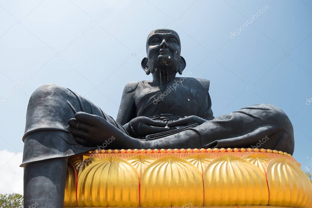 Statue of praying monk Luang Phor Thuad at Wat Bo Phuttharam, koh Samui, Thailand at picturesque green park