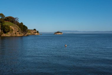 San Rafael Marin County, Kuzey Kaliforniya 'da Çin Kampı yakınlarındaki San Pablo Körfezi' ndeki Rat Rock küçük adasında bulutsuz bir günde mavi gökyüzü...