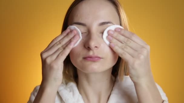 Kadın sarı bir arka plan üzerinde yüz temizleyici — Stok video