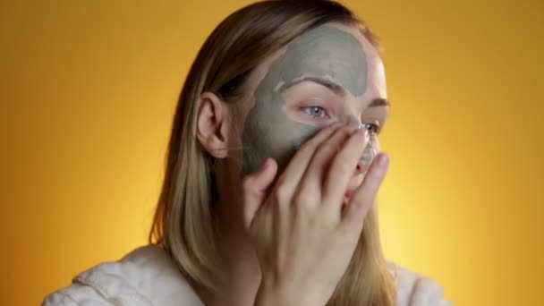 Beautiful blonde getting a facial on a yellow background — Stock Video